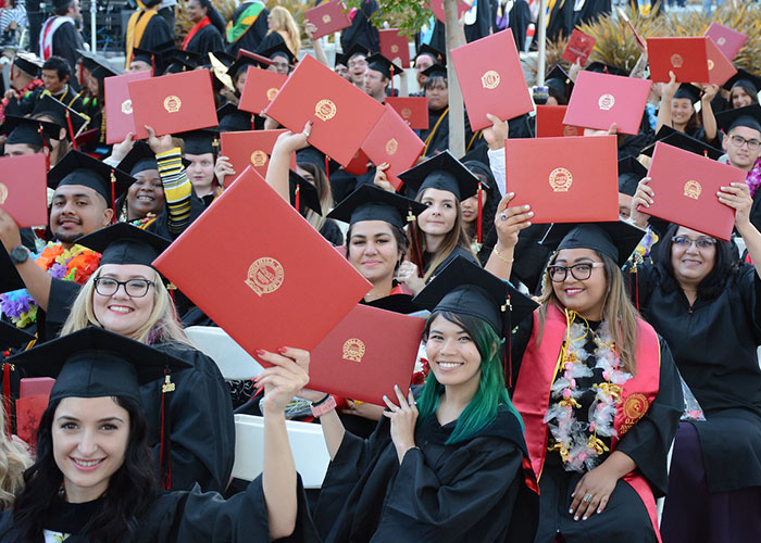 group of graduates holding degrees