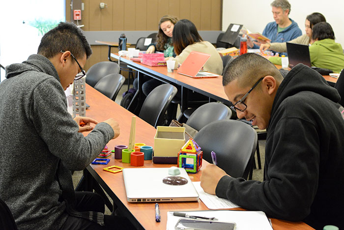 group of college students playing with toys in classroom