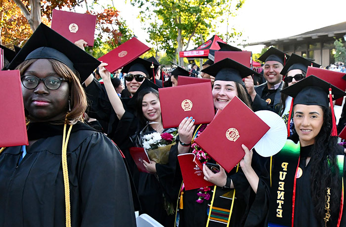 large group of students holding degrees