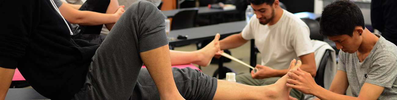 Two students learning to wrap a foot